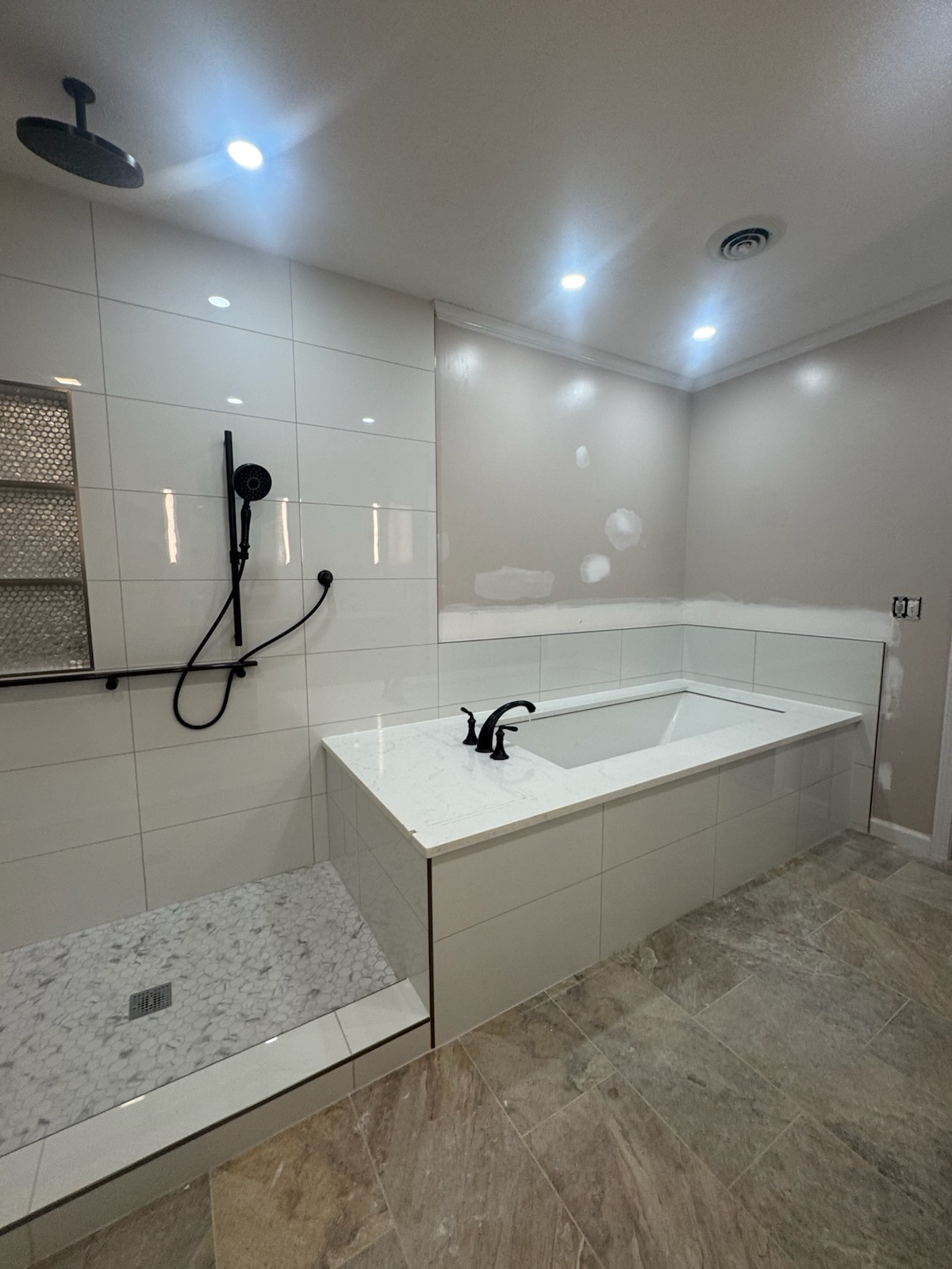 Completed bathroom remodel with tiled walk-in shower and soaking tub