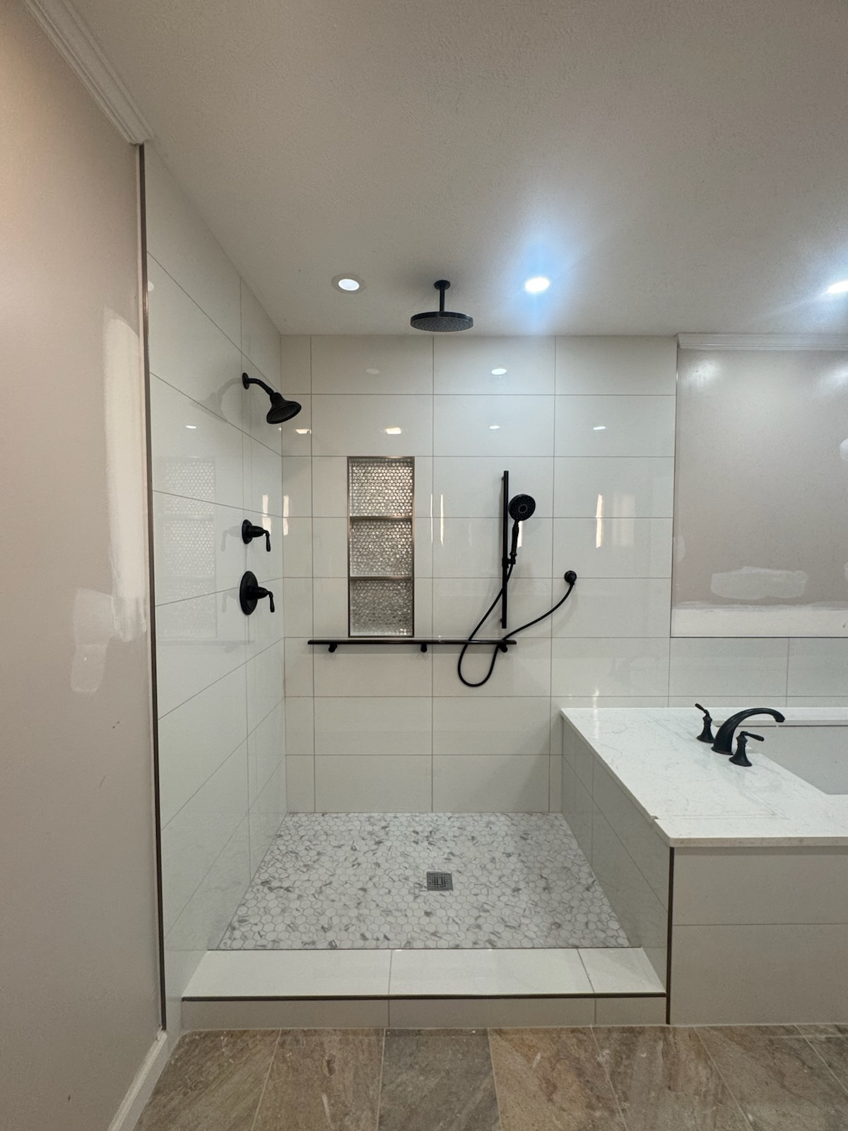 Completed tiled walk-in shower with black fixtures